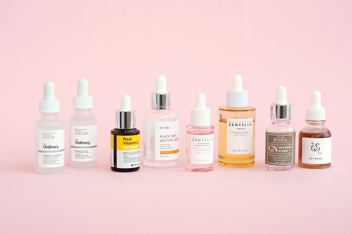 Frosted serum bottle beside botanical oils in warm editorial light